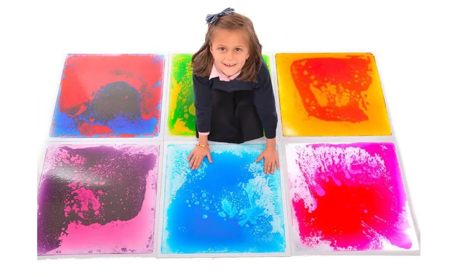 bimba seduta du piastrelle colorate di diversi materiali per stimolare la multisensorialità