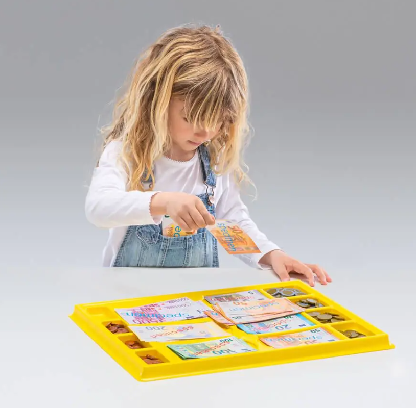gioco euro per contare in vassoio. Bambina che gioca con il vassoio con banconote finte