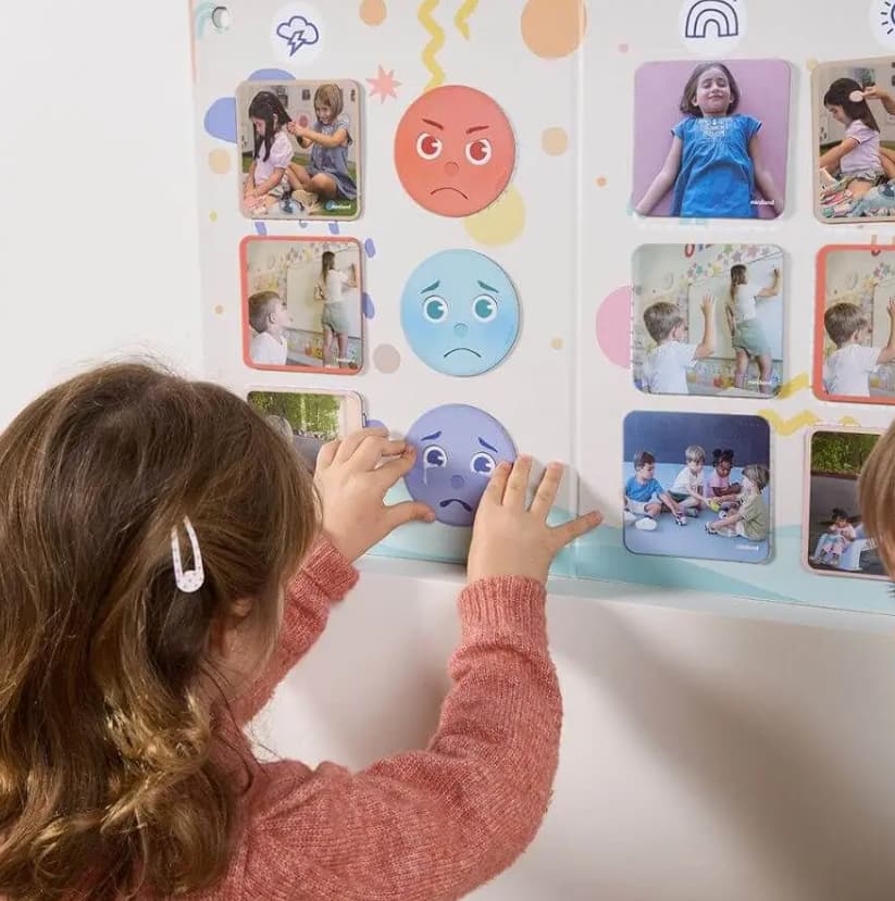 bambina che gioca con il gioco nei tuoi panni appeso al muro