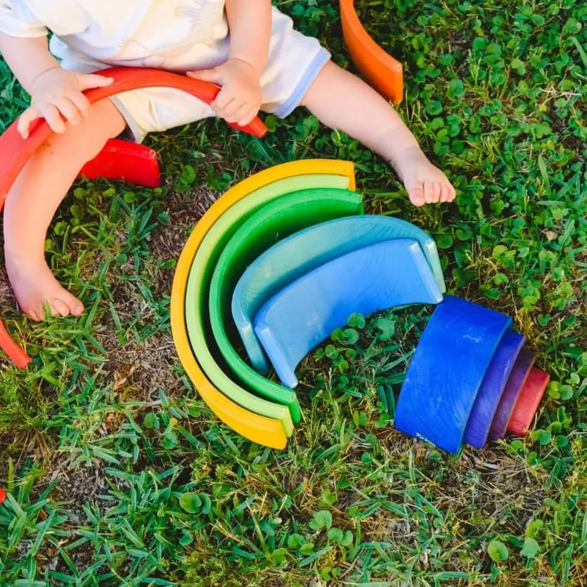 arcobaleno in legno grande, bambina che gioca
